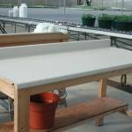 Clean greenhouse work table with non-porous surface