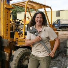 Christine Hatch wields large wrench as she assembles fiber-optic plow