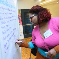 Lacresha Bowers writes on a board an outline of a plan for the Nutrition Education Program
