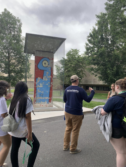 Summer Scholars give the youth a tour of campus, stopping at the historic art installation of the Berlin Wall. 