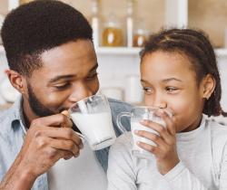 man and young girl drinking milk