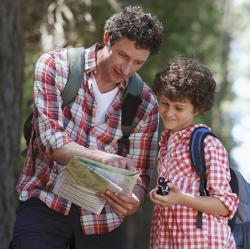 adult and child hiking with a map