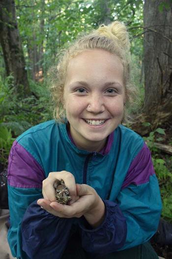 Kallin Lang holds wood thrush chick for ecological research 