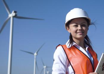 Professional woman in front of wind turbines