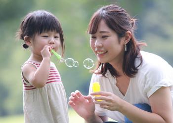 girl and mother blowing soap bubbles