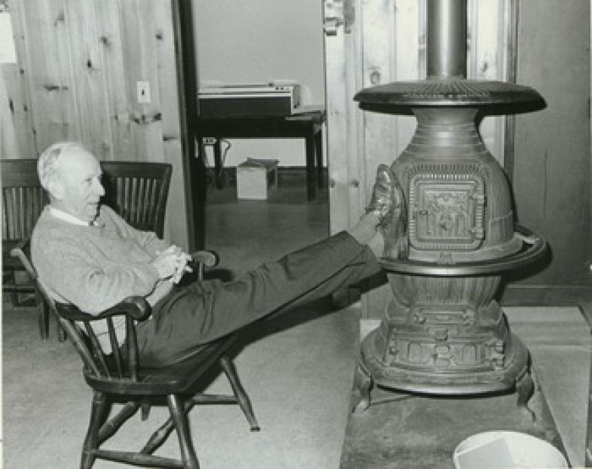 Dr. Chester Ellsworth Cross, with feet on woodstove