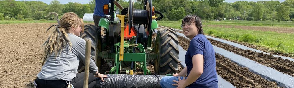 Matthew Bley rides a tractor while learning about healthy soils in the REEU program. 