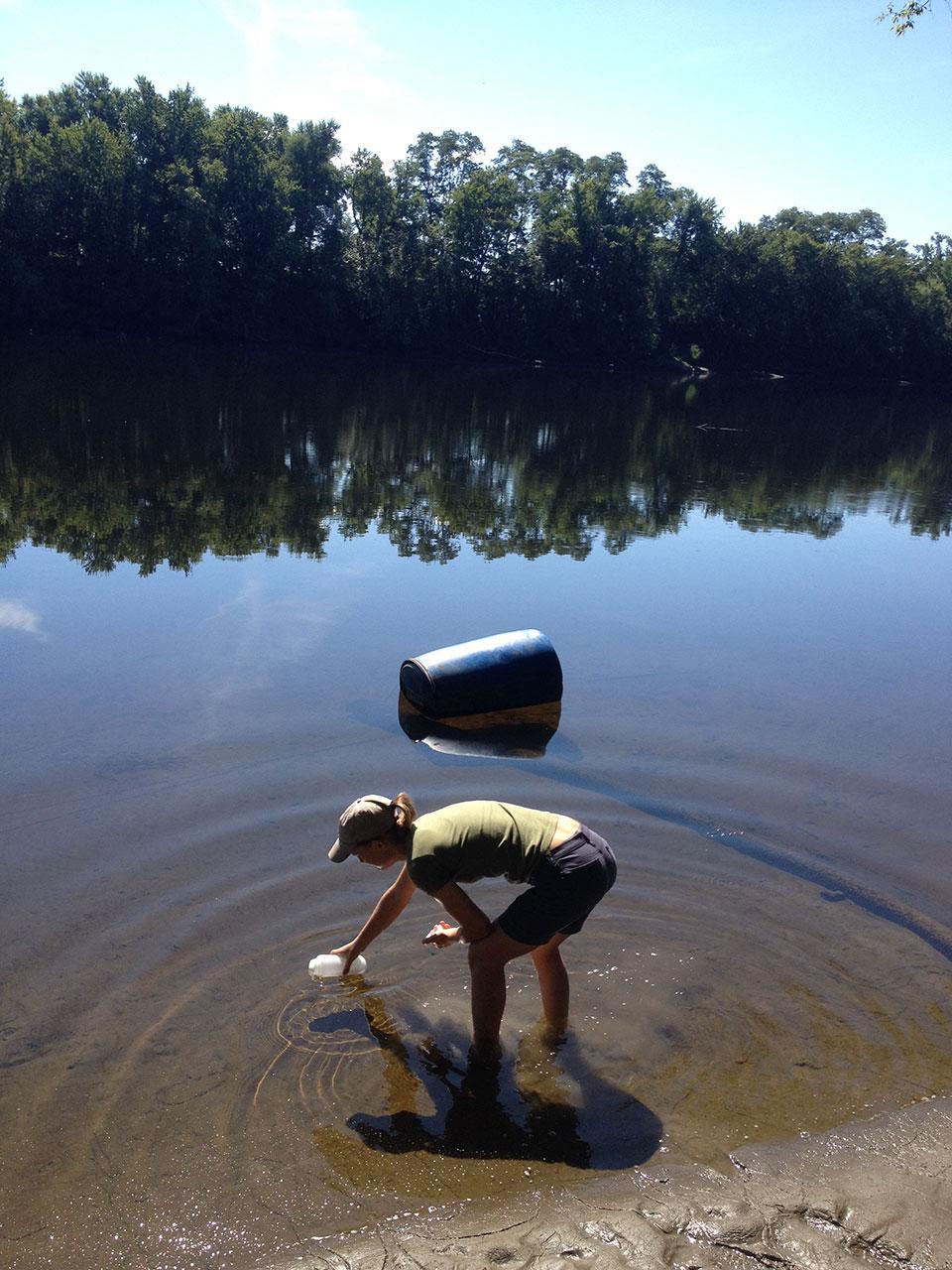 Research technician and Stockbridge undergraduate, Genevieve Higgins collecting water samples from the Connecticut River in Deerfield.