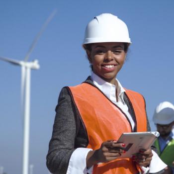 woman standing in front of wind turbine