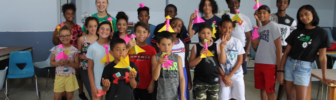 a group of kids holding paper rockets